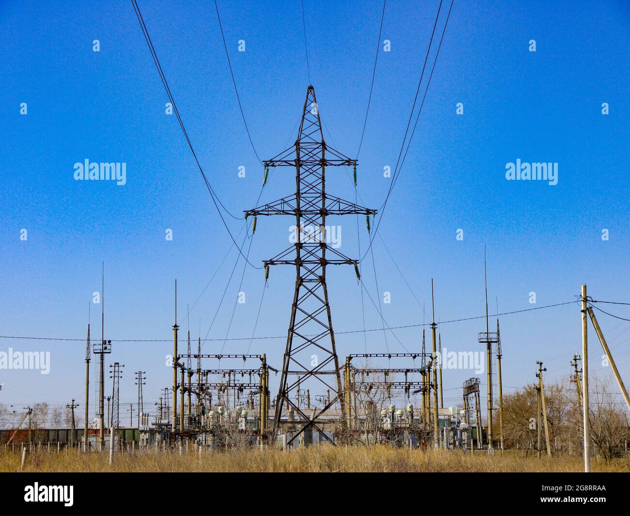 Elektrisches Umspannwerk zur Stromversorgung von Landesteilen. Hochspannungsausrüstung. Stromübertragungsmast gegenüber der blu Stockfoto