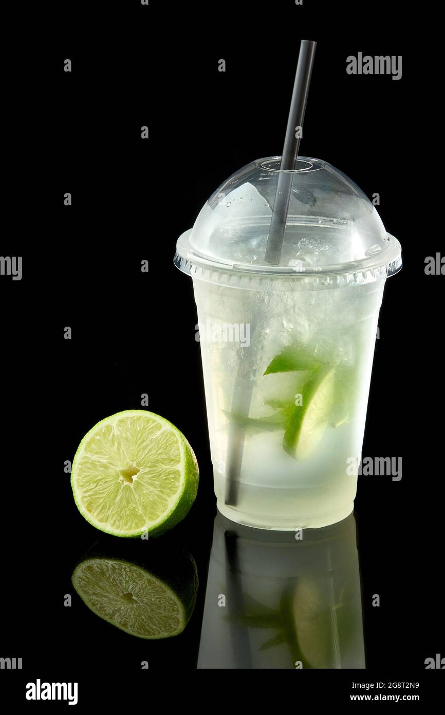 Limonade-to-go-Becher mit Minze, Limette und Kiwi auf schwarzem Hintergrund, isoliert Stockfoto