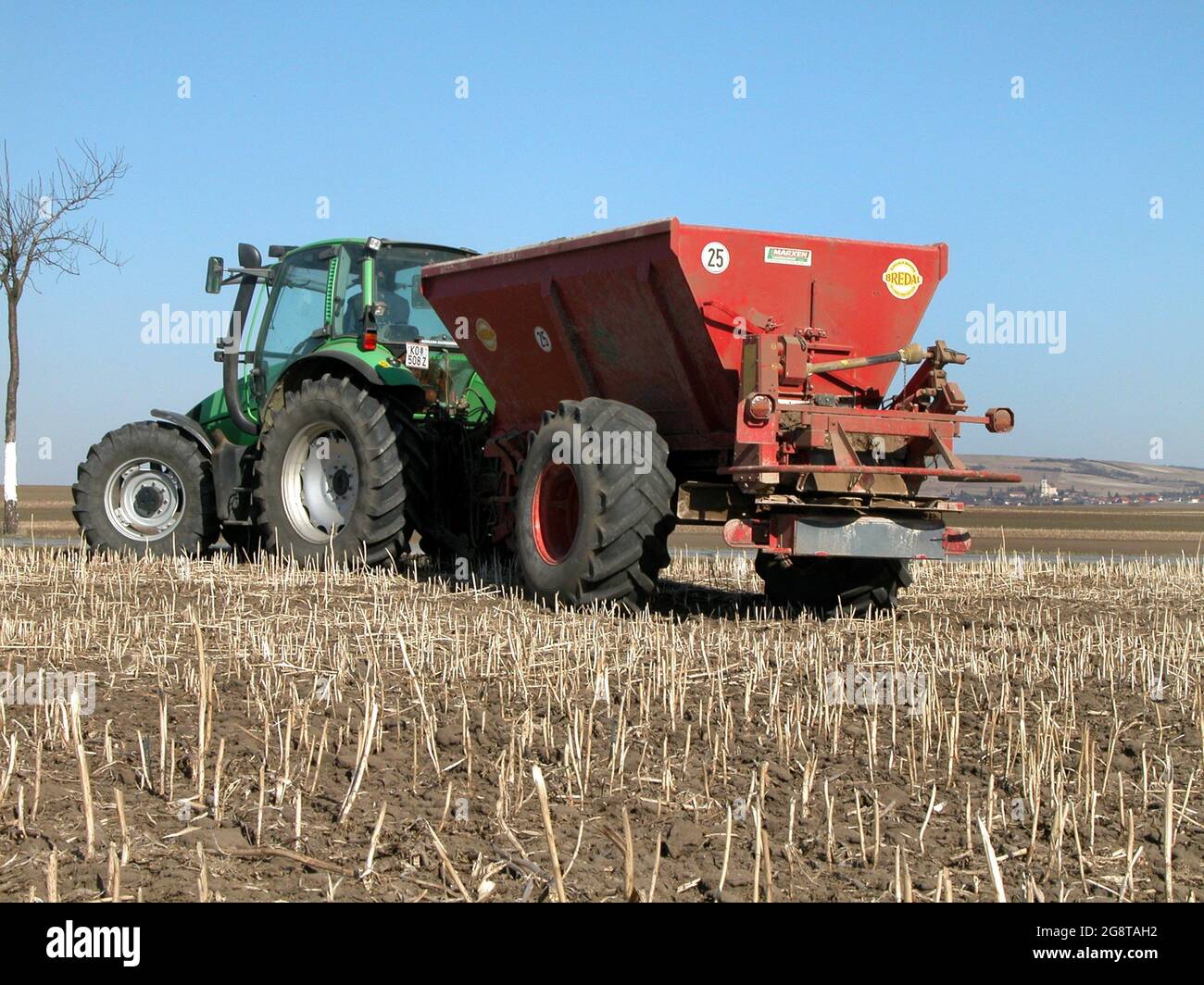 Landwirt mit Traktor, der mit einem Dungstreuer auf den Feldern arbeitet, Österreich, Niederösterreich Stockfoto