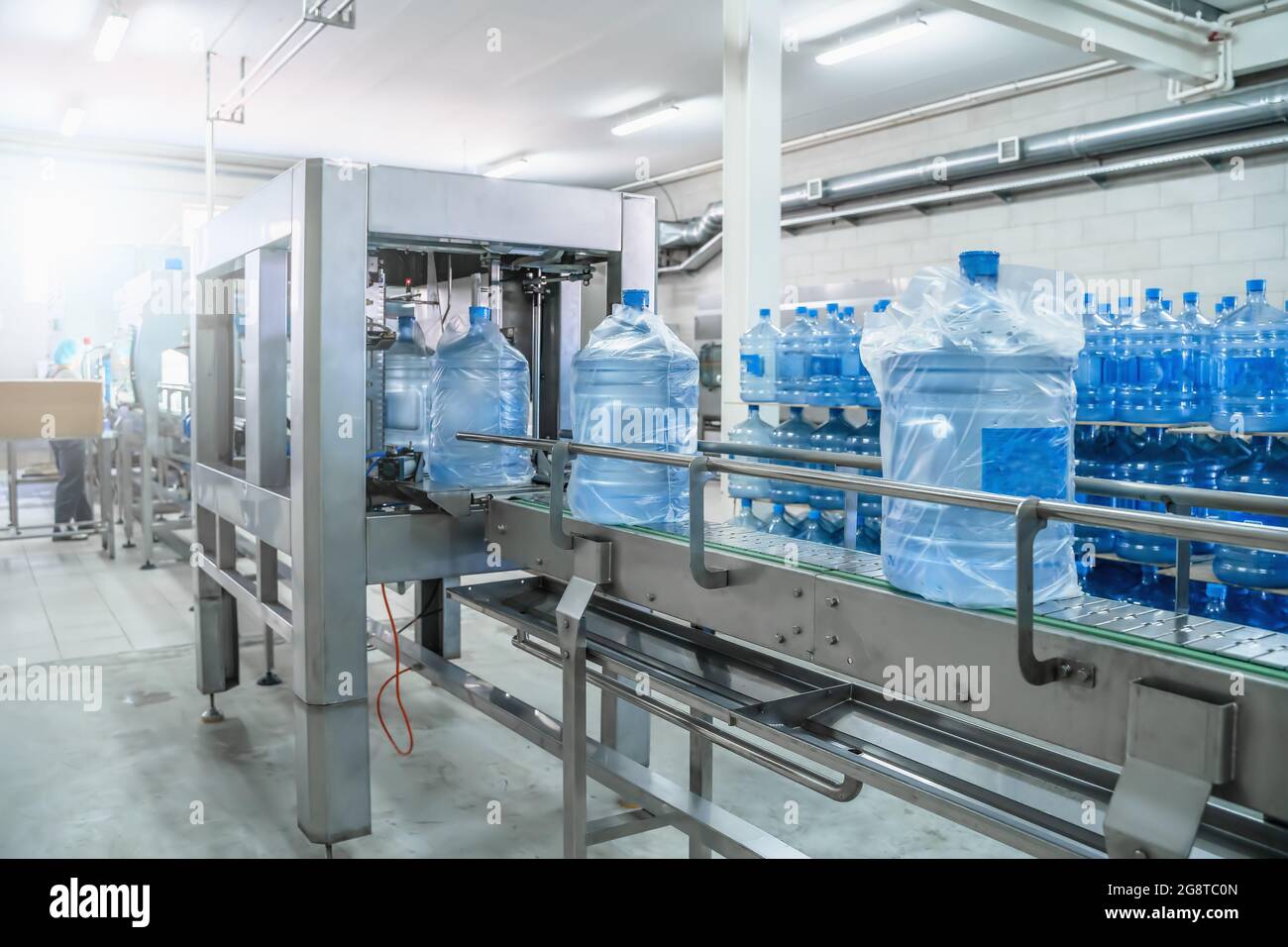 Produktionsprozess Herstellung gereinigtes Trinkwasser und Verpackung in Kunststoffflaschen in der Getränkeherstellung, Lebensmittelindustrie, Förderband. Stockfoto