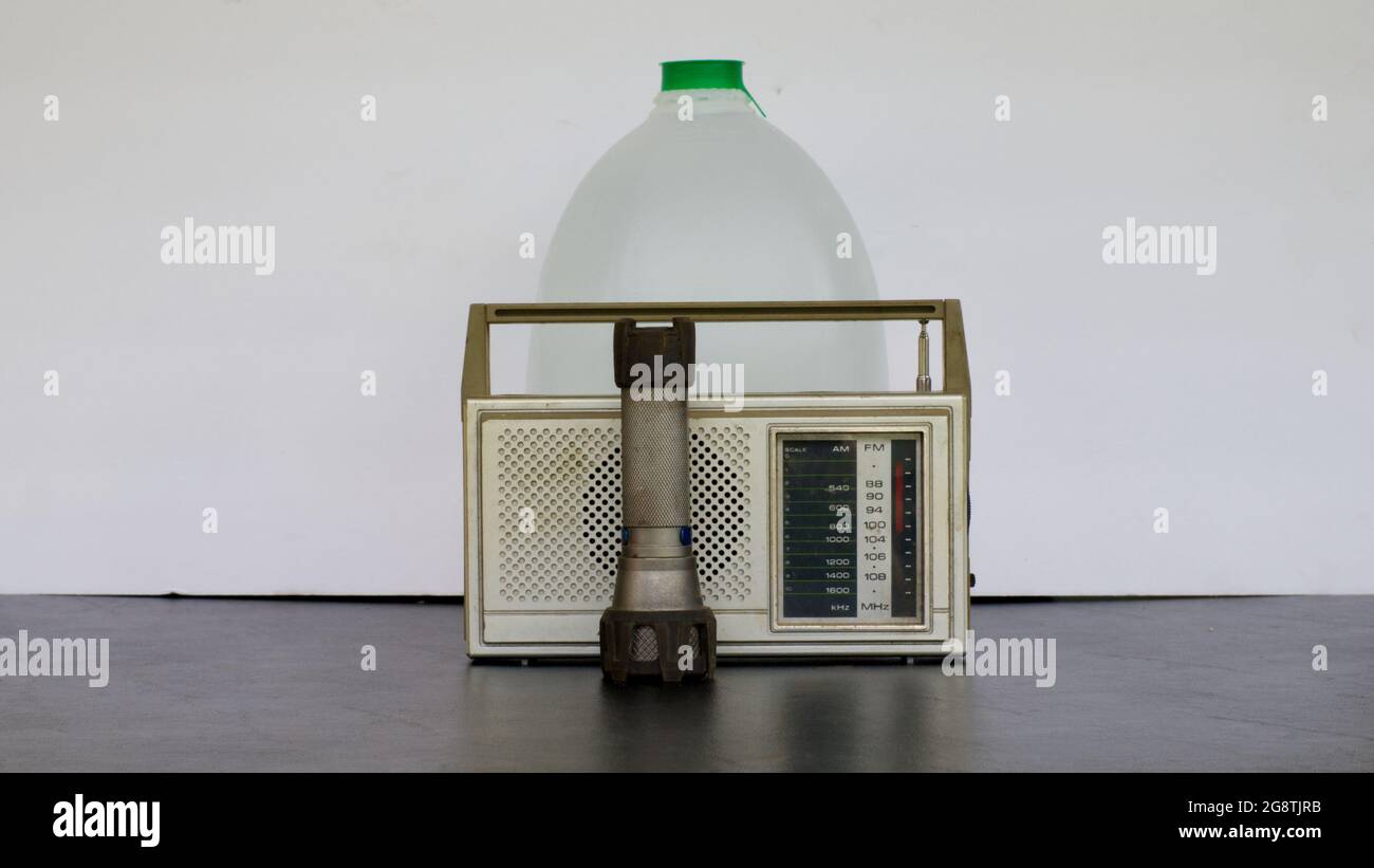 Eine Taschenlampe, ein batteriebetriebenes Radio und eine Gallone Trinkwasser Stockfoto