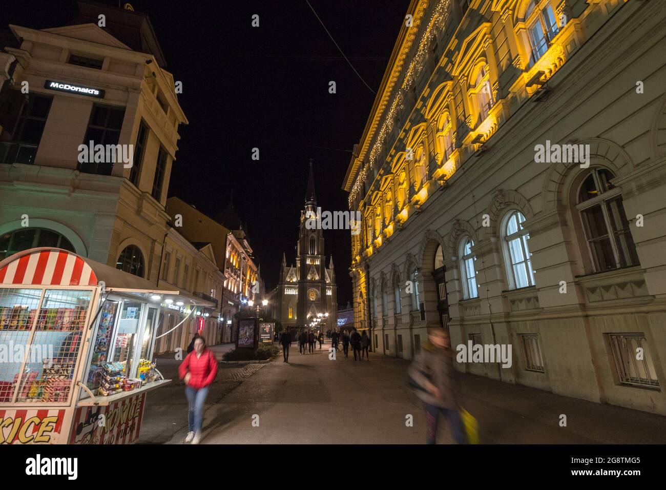 Bild der Kathedrale von Novi Sad auf dem Platz Trg Slobode mit vorbeifahrenden Fußgängern. Der Name der Maria Kirche ist eine römisch-katholische Pfarrkirche gewidmet Stockfoto