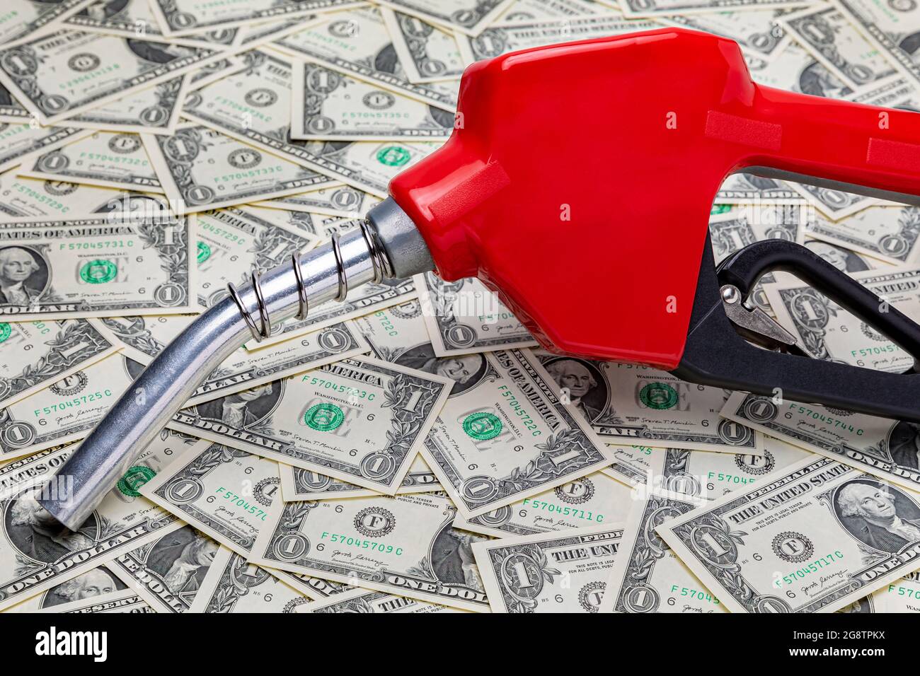 Benzindüse und Geldbörse mit Bargeld. Konzept für Gaspreise, Steuern, Ethanol und fossile Brennstoffe Stockfoto