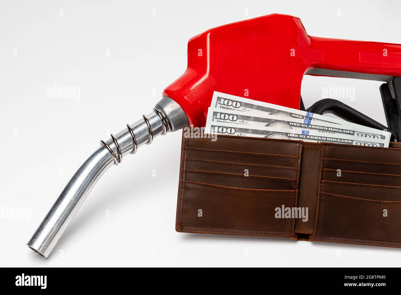 Benzindüse und Geldbörse mit Bargeld. Konzept für Gaspreise, Steuern, Ethanol und fossile Brennstoffe Stockfoto