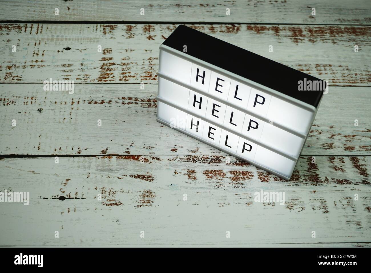 Hilfewort Text in Lichtbox auf hölzernem Hintergrund Stockfoto