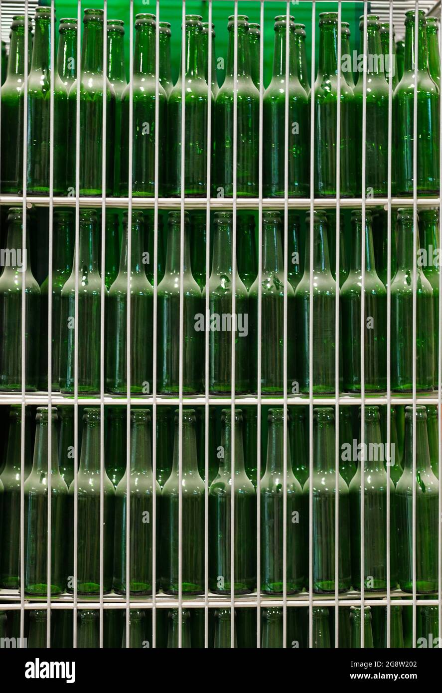 Viele transparente grüne staubige Bierglasflaschen in Reihe, aus nächster Nähe. Textur der Glasflasche... Stockfoto