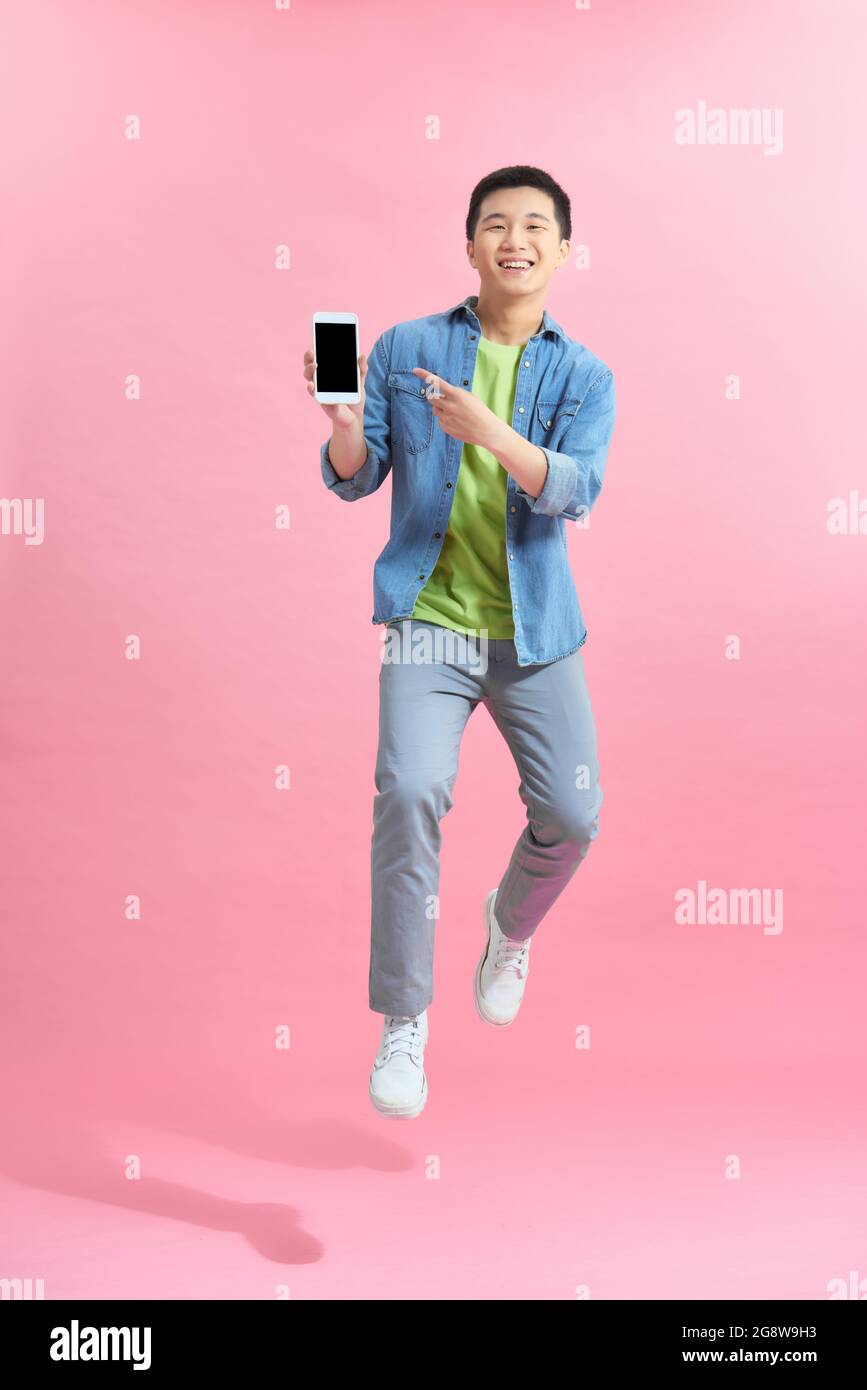 Junger Mann demonstriert Smartphone mit Modell für mobiles App-Design Stockfoto