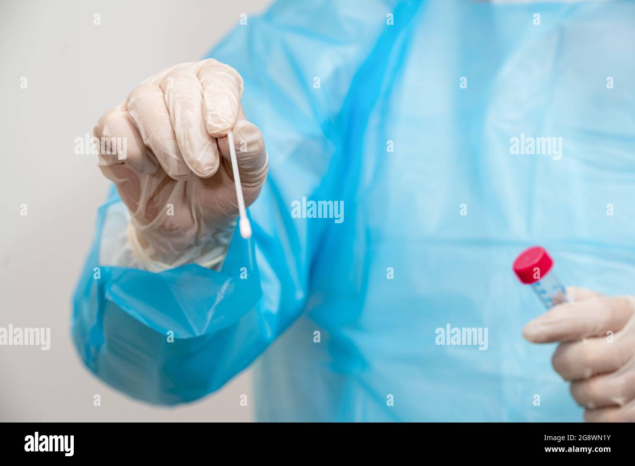 Ein medizinisches Personal, das ein Set zur Probenentnahme für Tupfer in der Hand hält. Stockfoto