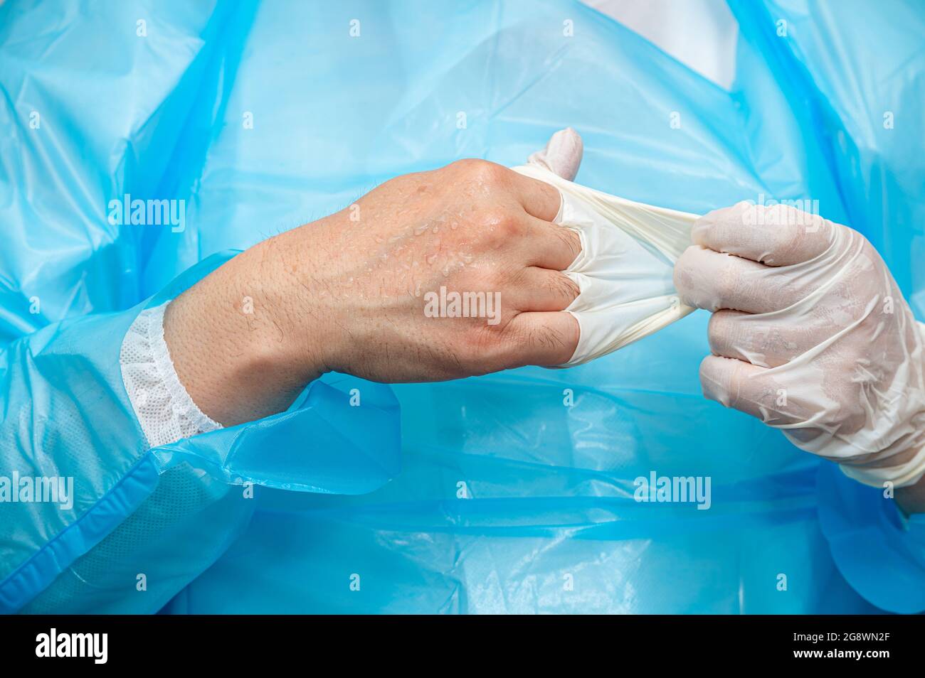 Ein Arzt, der in der Hitze verschwitzte Handschuhe trägt. Stockfoto