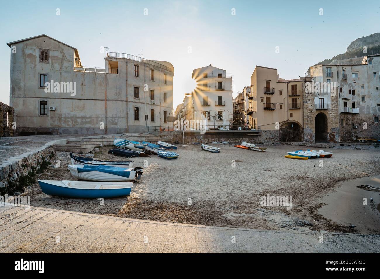 Schöner alter Hafen mit hölzernen Fischerbooten, bunten Steinhäusern am Wasser und Sandstrand in Cefalu, Sizilien, Italien. Attraktive Sommer-Stadtlandschaft, t Stockfoto