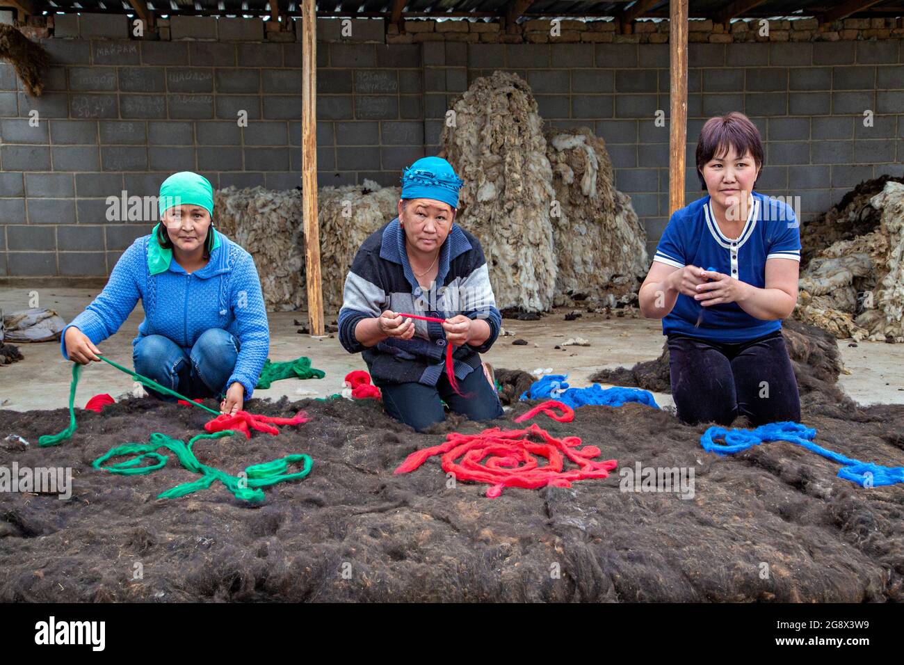 Kirgisische Frauen, die Filzteppich auf traditionelle Weise in Issyk Kul, Kirgisistan, machen. Stockfoto