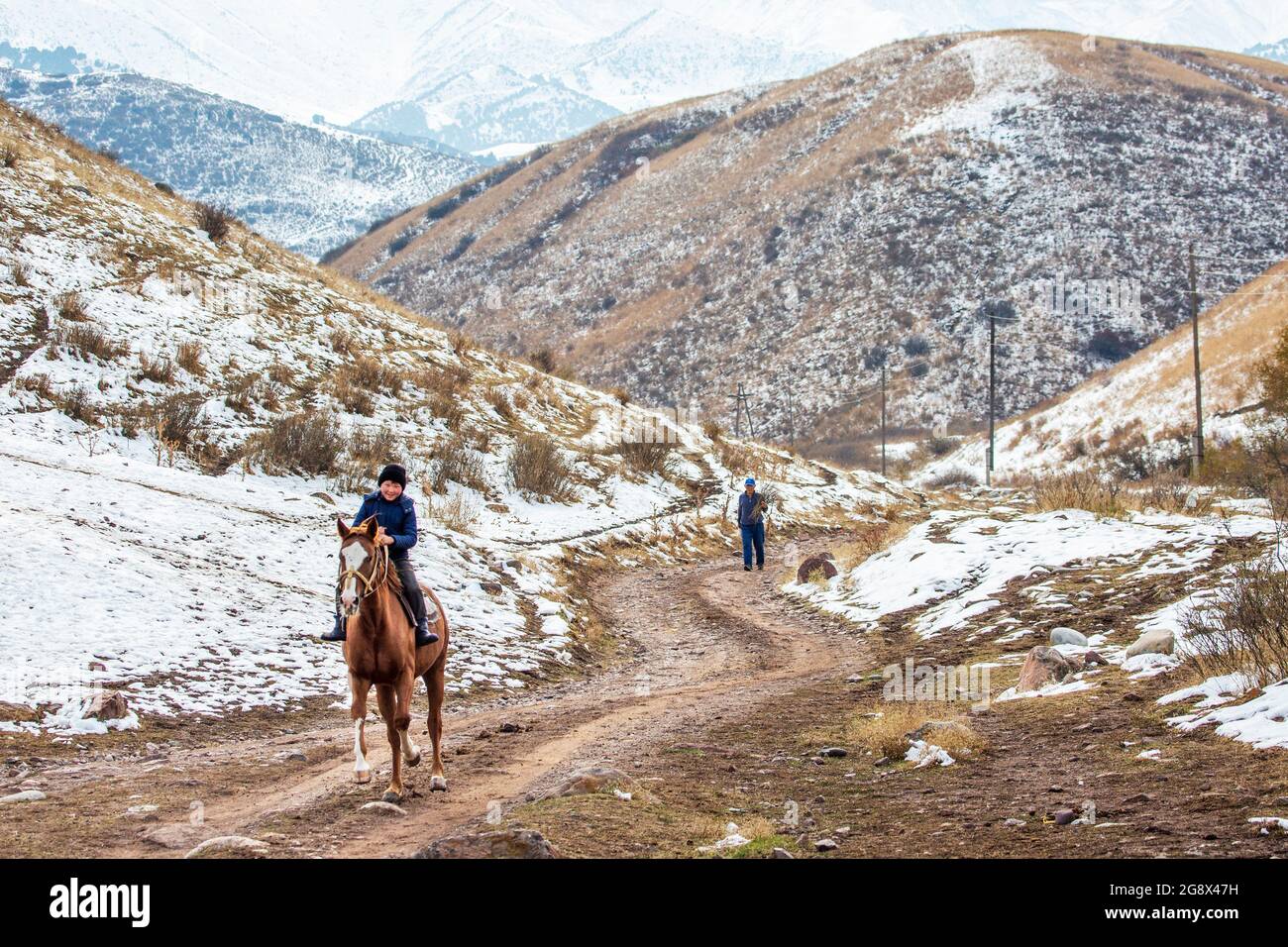 Nomadischer Junge, der in der Nähe von Bischkek, Kirgisistan, reitet Stockfoto