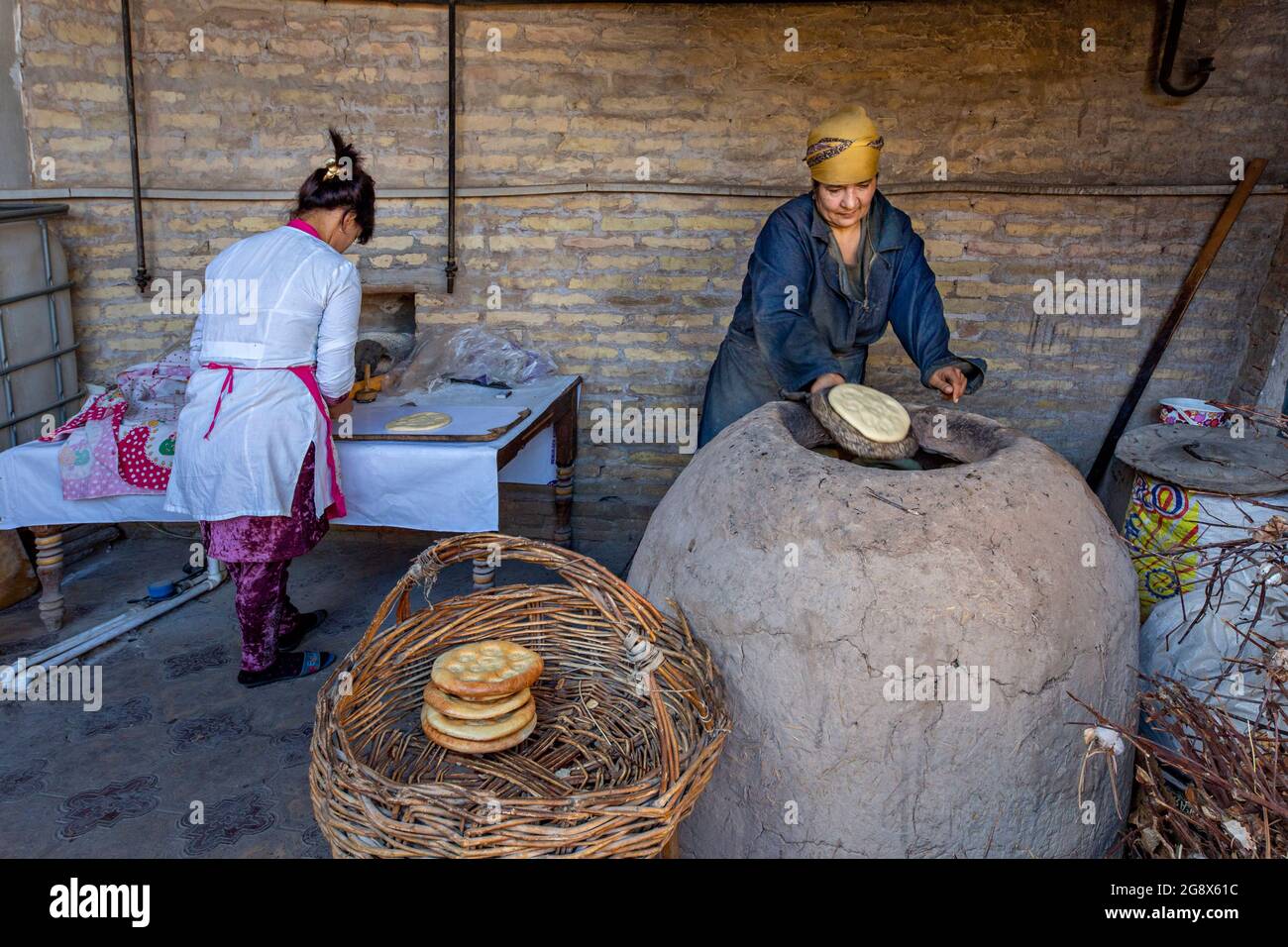 Usbekische Frauen, die in Chiwa, Usbekistan, Tandoori-Brot backen. Stockfoto