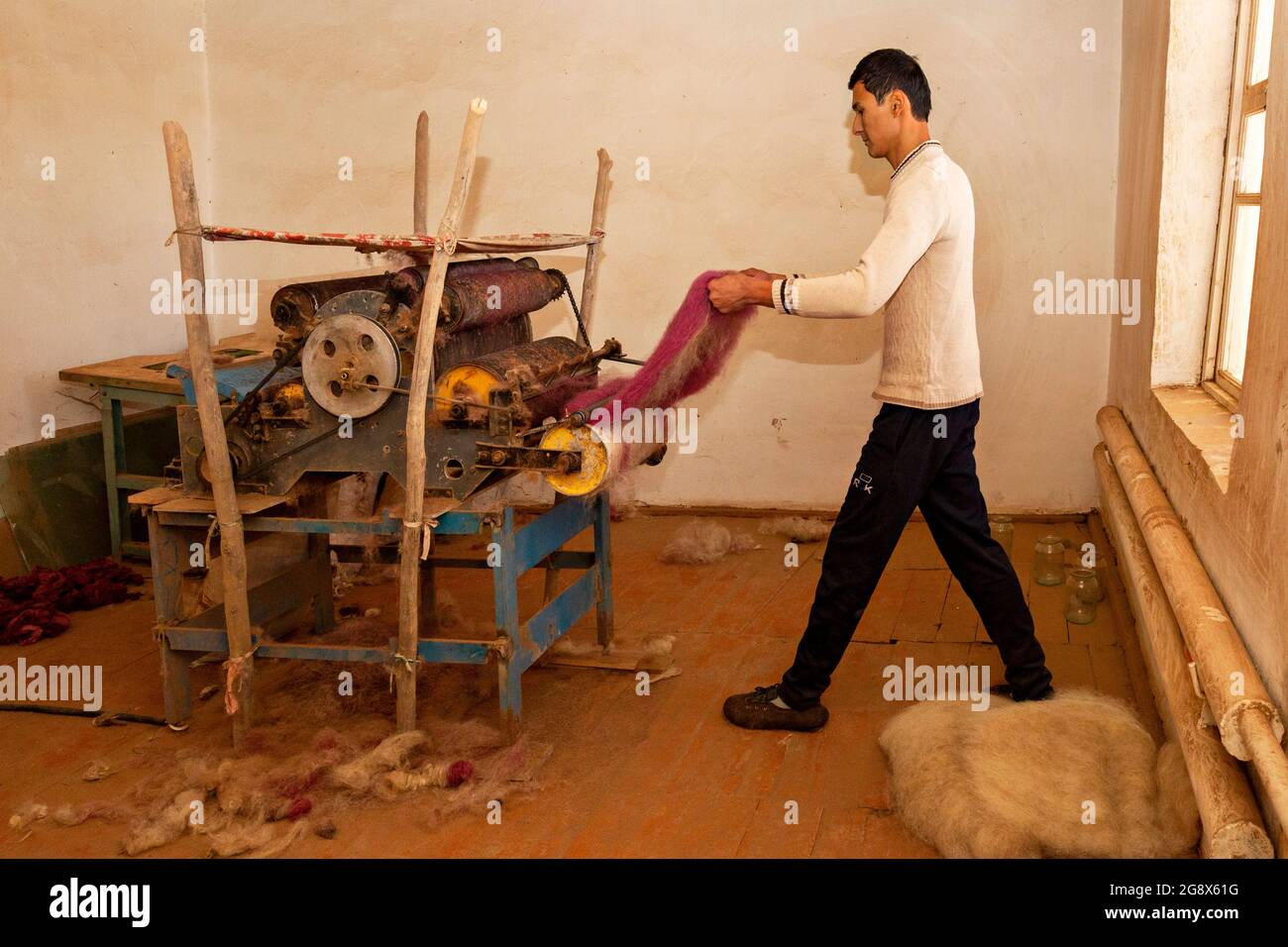 Usbekischer Mann, der den Filz mit einer traditionellen Maschine in Nukus, Usbekistan, abflacht Stockfoto