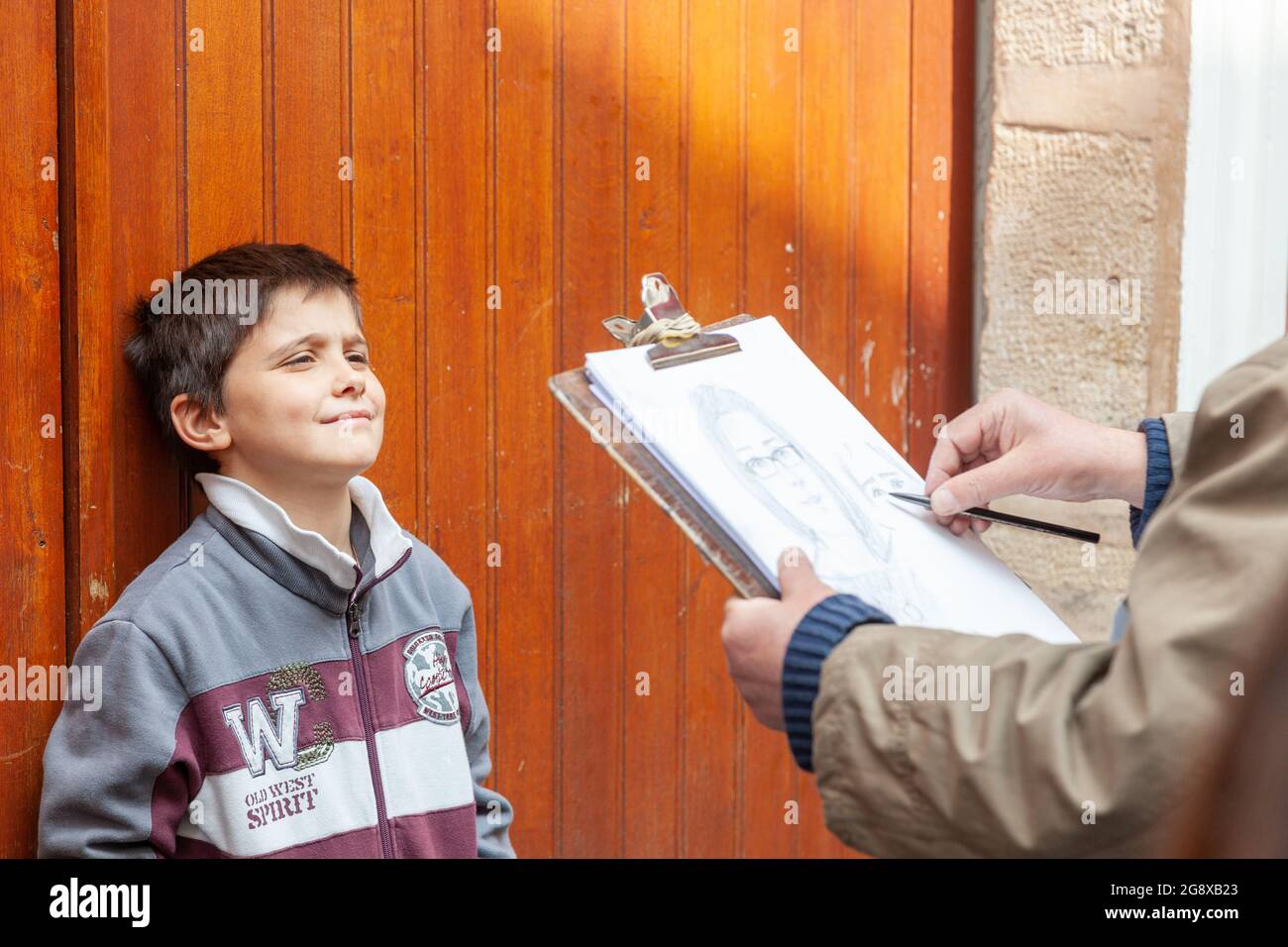 Der kleine Junge, der sein Porträt auf der Straße im Pariser Montmartre-Viertel aufgenommen hat Stockfoto