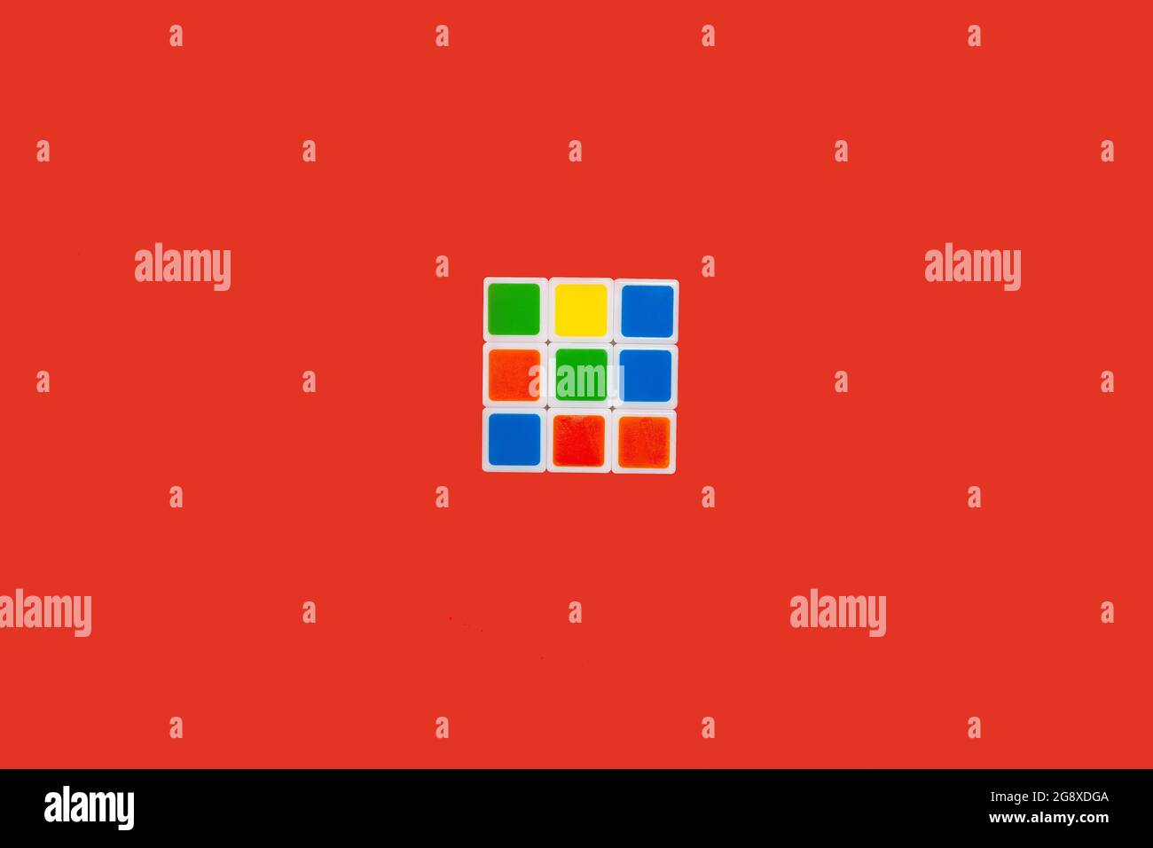 Rubiks Würfel auf rotem Hintergrund. Spielzeug Stockfoto
