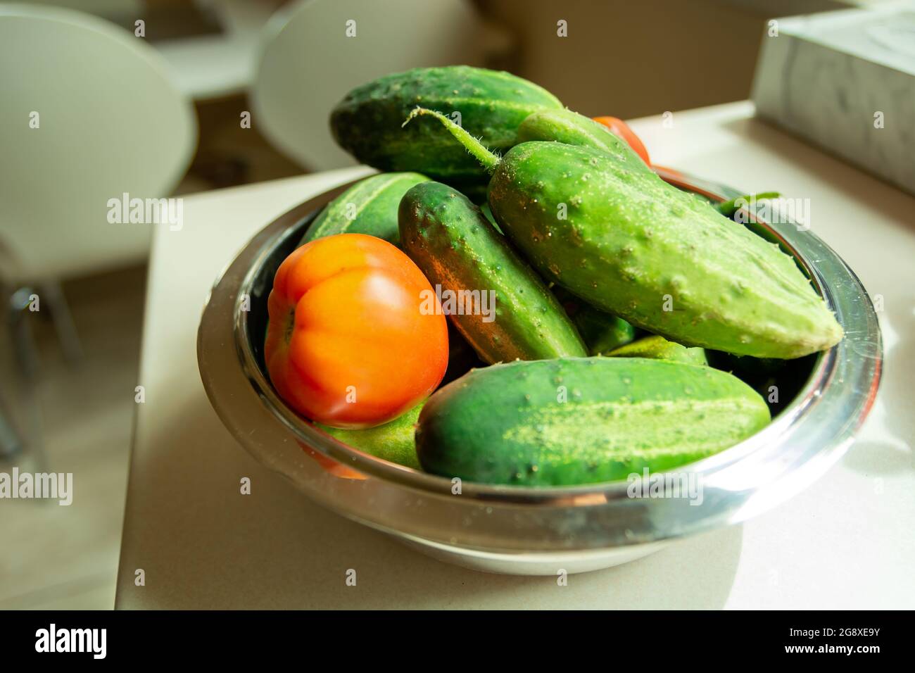 Frische Tomaten und Gurken in einer Schüssel, Sommertag Stockfoto