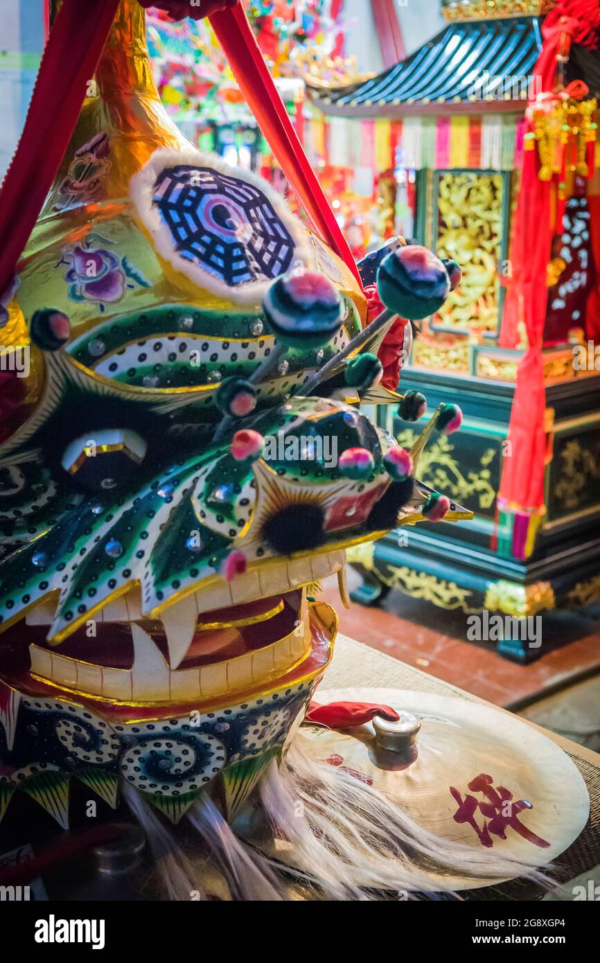 Der Kopf eines Löwentanzkostüms und eines Schreins im Tin Hau Tempel, Peng Chau, einer abgelegenen Insel Hongkongs, für das jährliche Tin Hau Festival Stockfoto