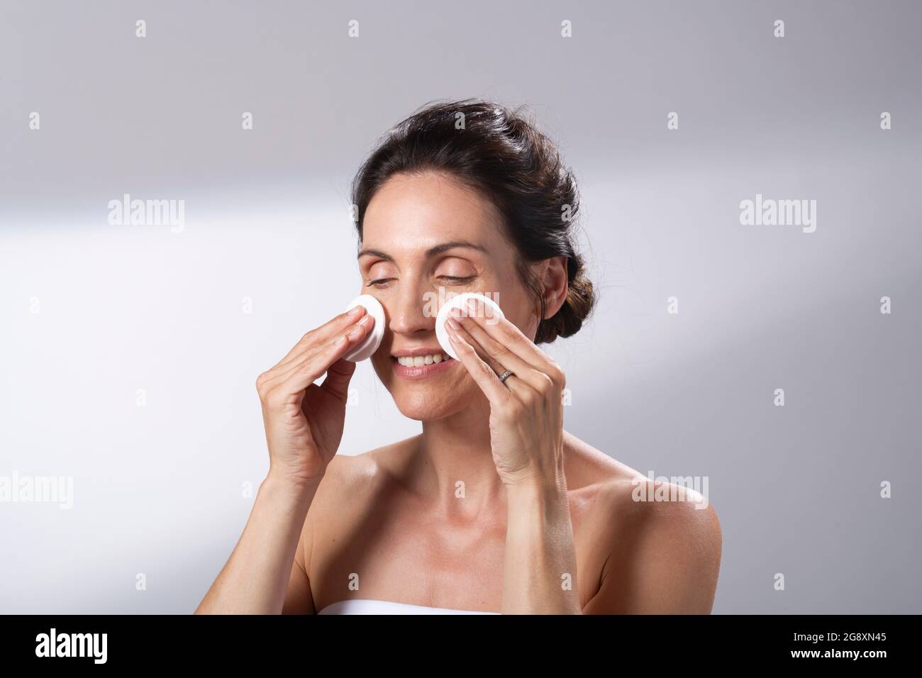 Eine Frau, die ein Paar Wattepads verwendet. Reinigt ihr Gesicht. Stockfoto