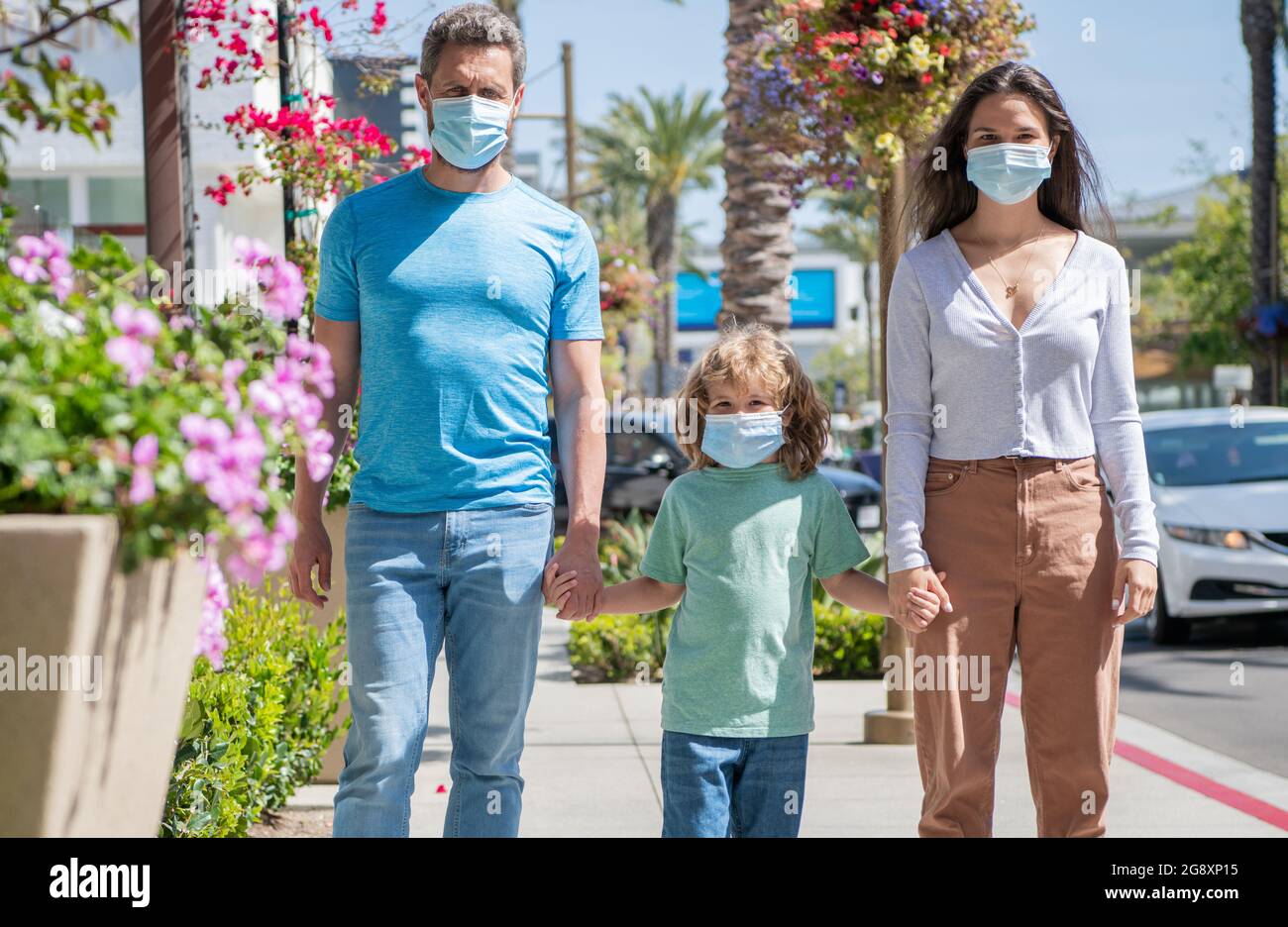 Familie während der Coronavirus-Pandemie. Eltern mit Kind Junge tragen medizinische Maske. Stockfoto