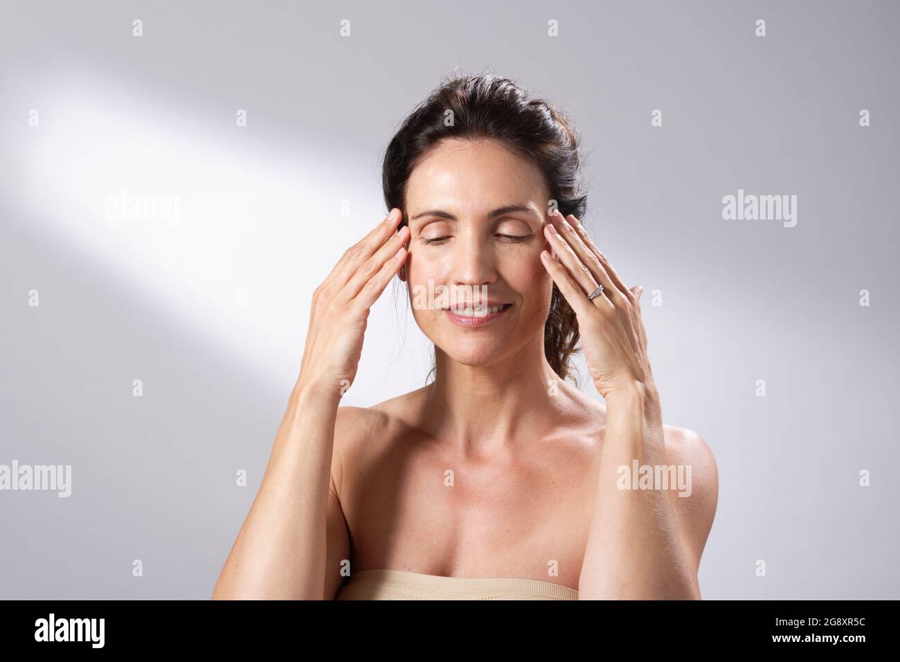 Das Hautpflegeregime einer Frau. Hände und Finger auf dem Gesicht und sanft einmassieren. Stockfoto