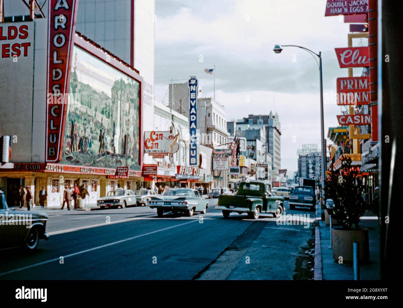 Ein Blick auf die North Virginia Street, Reno, Nevada, USA im Jahr 1961. Unterhaltungsmöglichkeiten wie Harold's Club (links) und der Nevada Club (Mitte) dominierten diese Straße. Harold’s Club wurde 1935 gegründet. Vor dem Casino wurde ein großes 70 x 35 Meter großes Wandgemälde mit alten Pioniersiedlern aus dem Westen, das einen Wagenzug und Indianer zeigt, ausgestellt. Das Gebäude wurde 1999 abgerissen. Das Wandgemälde wurde 2007 im Reno Livestock Events Center ausgestellt. Dieses Bild stammt von einem alten amerikanischen Amateur Kodak Farbtransparenz – einem alten Foto aus den 1960er Jahren. Stockfoto