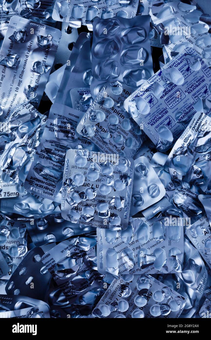 Kühle, blau getönte, verschreibungspflichtige Medikamententisch-Blisterpackungen, die auf das Recycling warten. Stockfoto