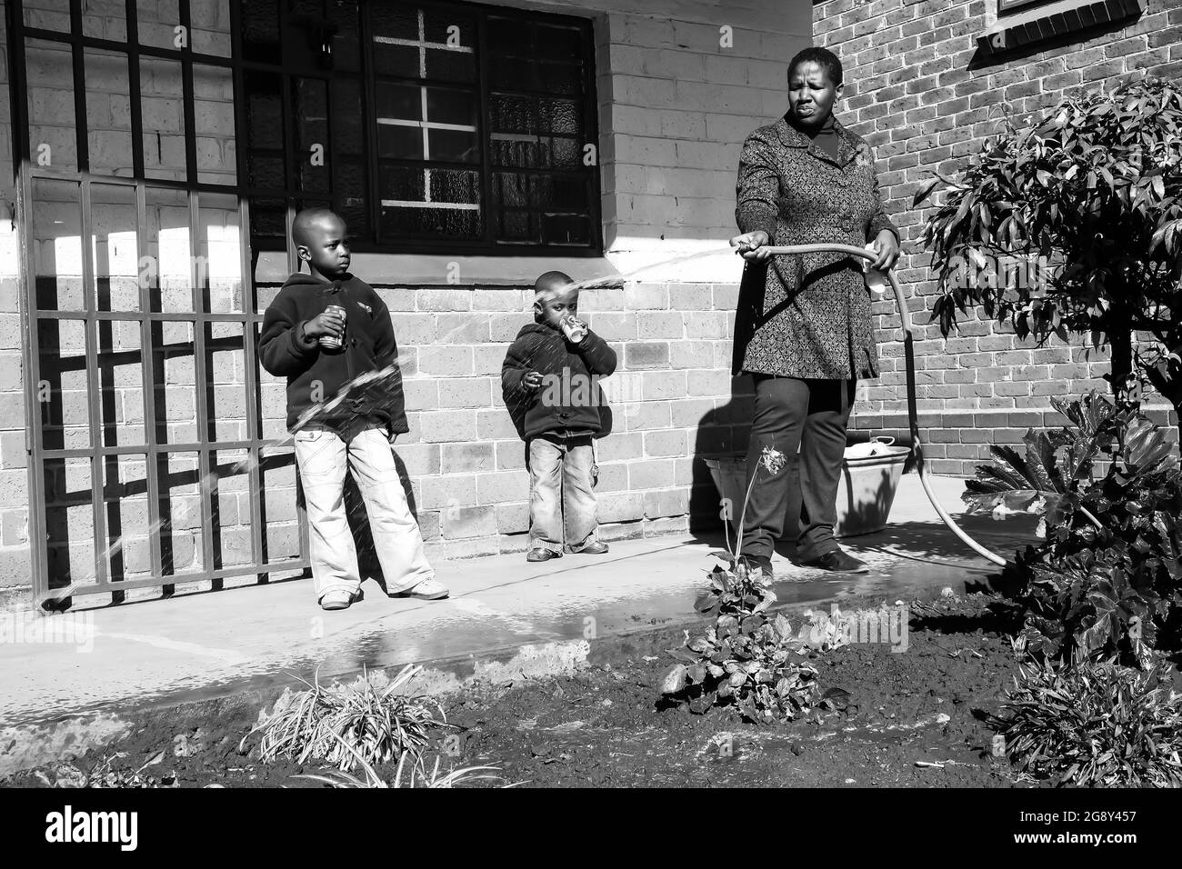 JOHANNESBURG, SÜDAFRIKA - 05. Jan 2021: Eine afrikanische Frau, die in der örtlichen Township-Schule einen Gemeinschaftsdienst im Garten durchführt Stockfoto