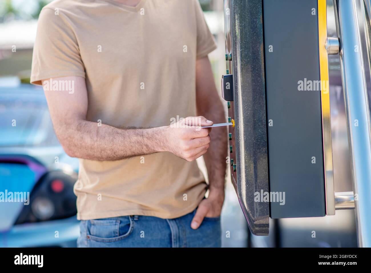 Männliche Hand, die Karte in der Nähe des Wandlesers hält Stockfoto