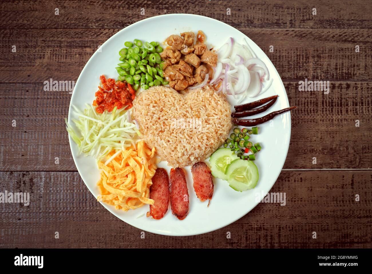 Beliebte thailändische einheimische Lebensmittel, gebratener Reis mit Garnelenpaste servieren mit Gemüse, Ei in Scheiben geschnitten und würzige Zutaten, verschiedene Gemüsesorten Stockfoto