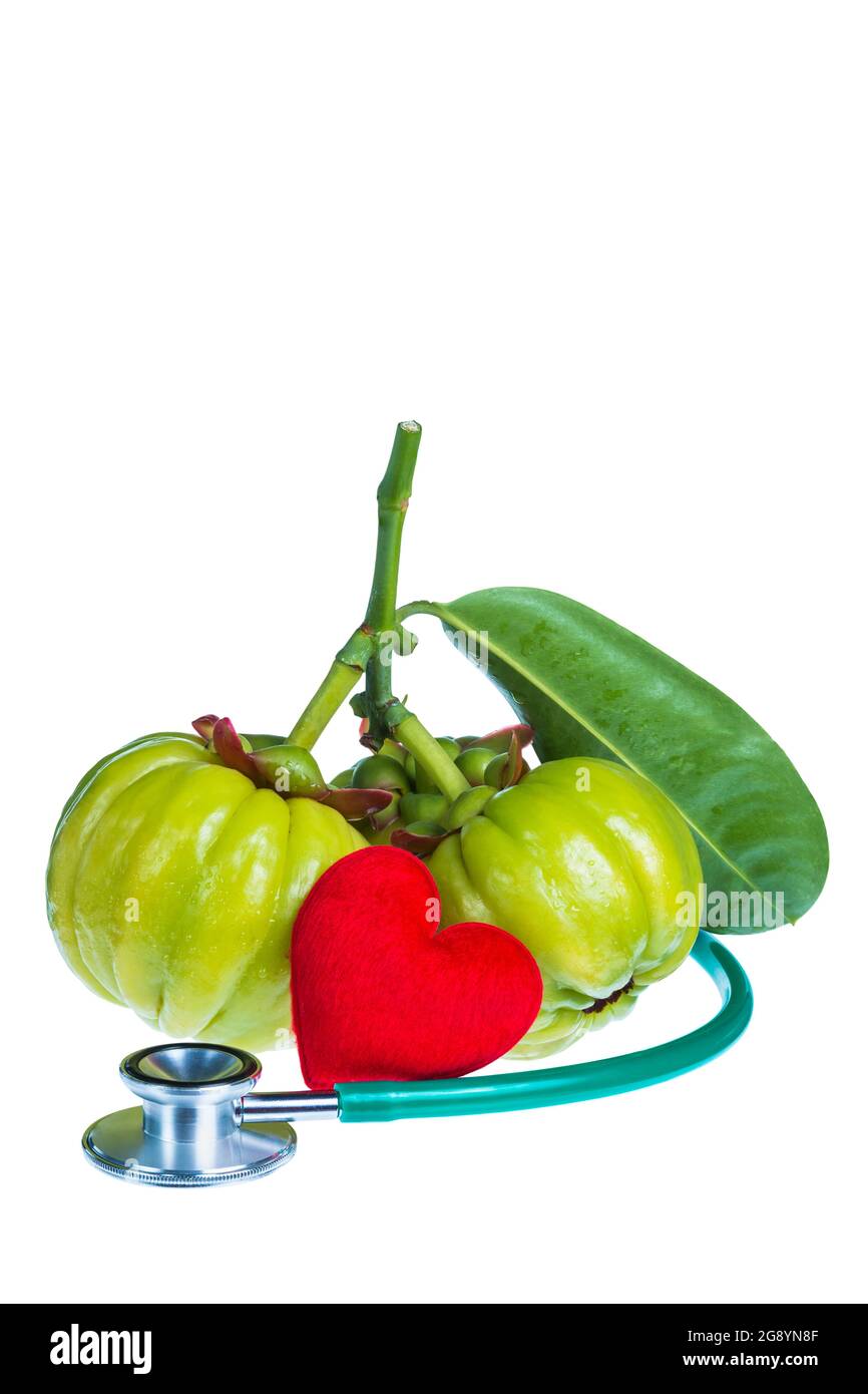 Stillleben garcinia atroviridis frische Früchte, rote herzförmige und Stethoskop. Isoliert auf weißem Hintergrund. Thai Kraut und sauer schmecken viel Vitamin Stockfoto