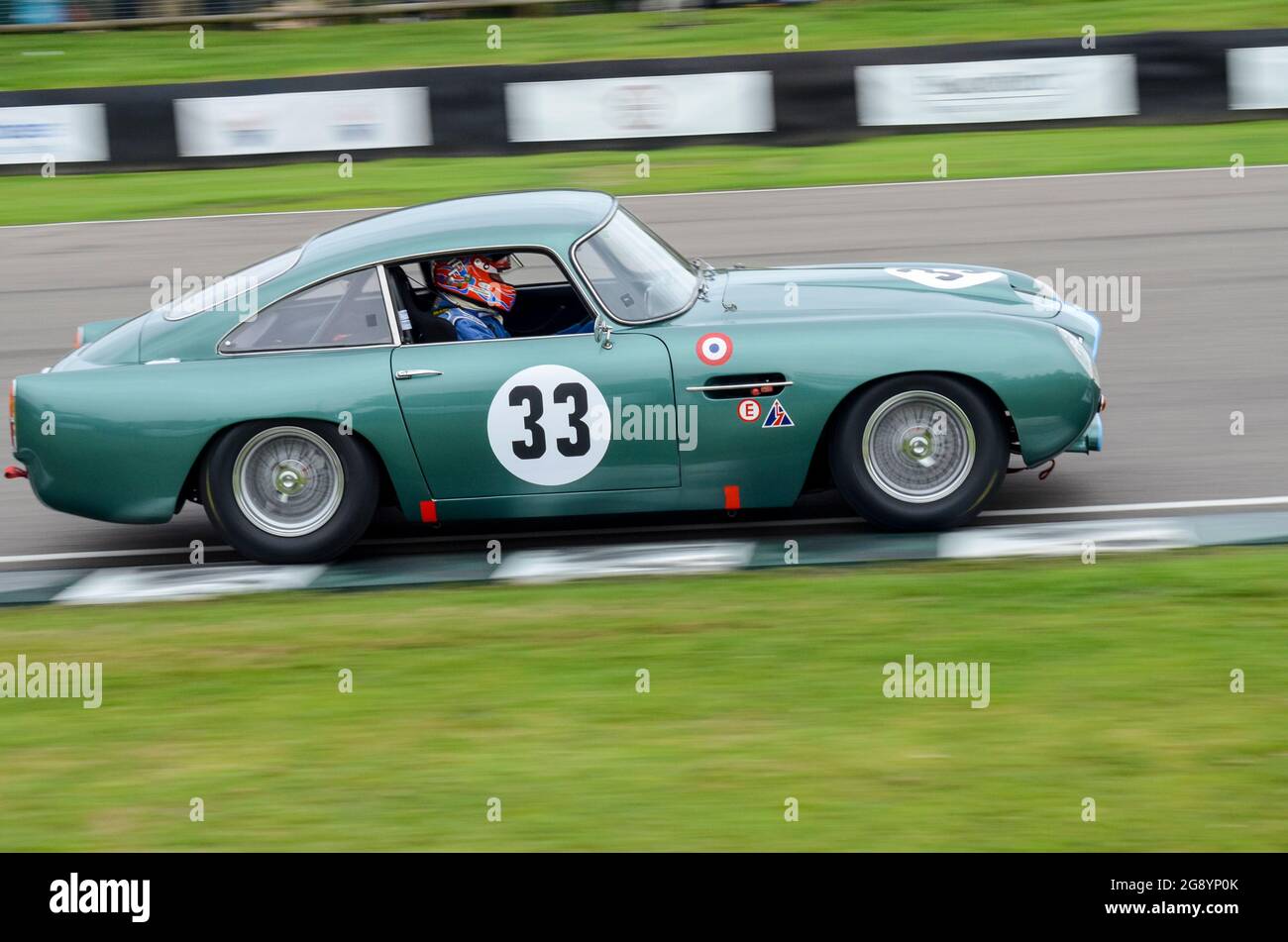 Aston Martin DB4GT Rennwagen bei einer Wet RAC Tourist Trophy beim historischen Goodwood Revival Event in Großbritannien. Angetrieben von TIFF Needell Stockfoto