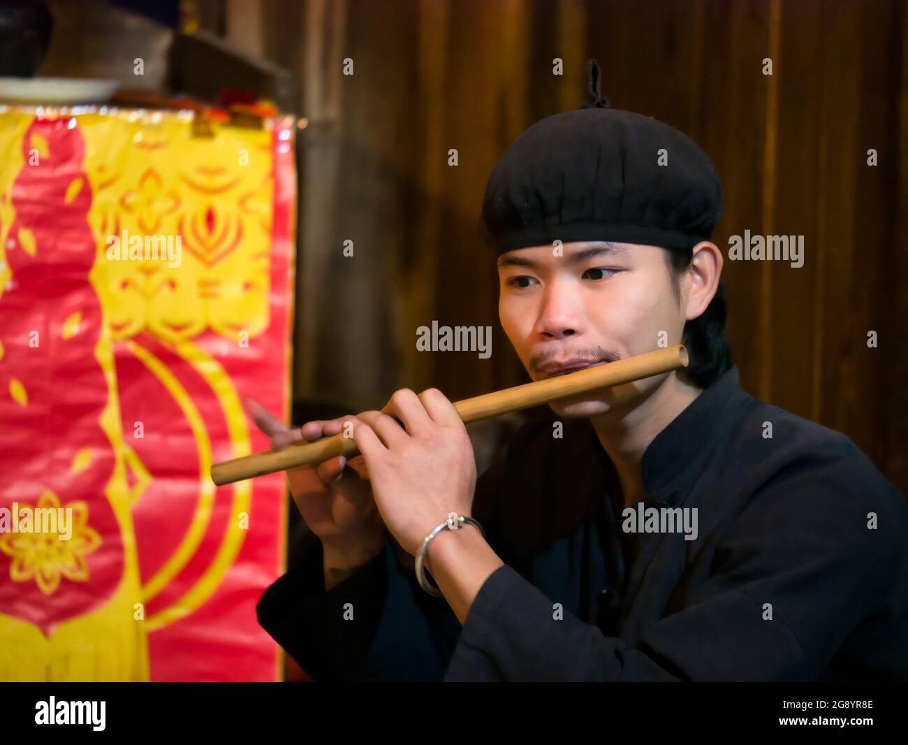 Junger Mann spielt traditionelle Musik Flöte in Thai Hai ethnischen Dorf, Thai Nguyen Provinz, Nordvietnam, Asien Stockfoto