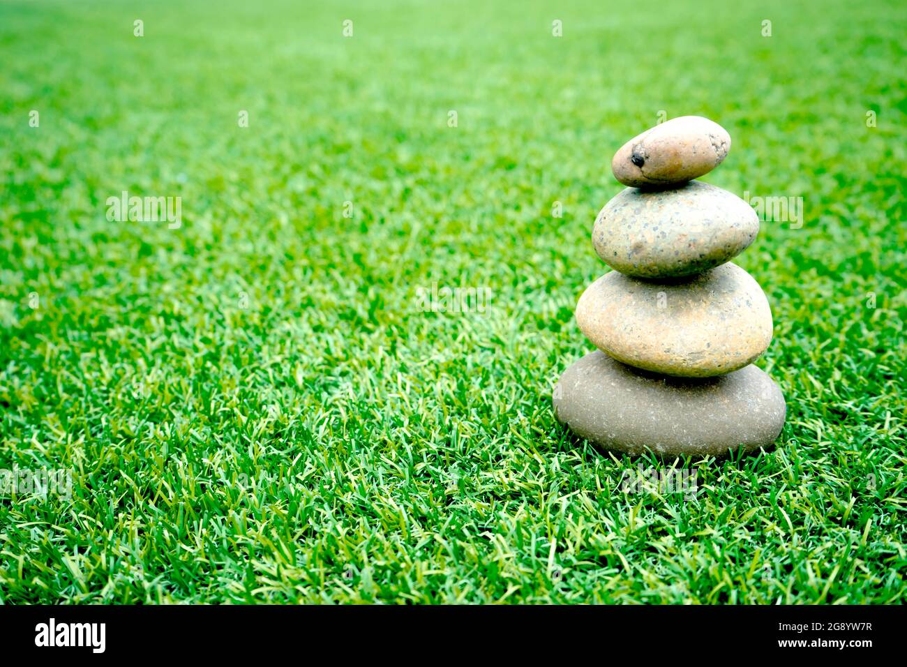 Auf Gras gestapelte Steine Stockfoto