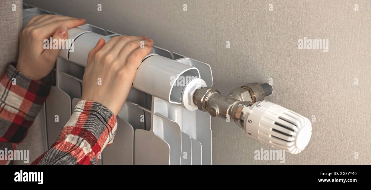 Mädchen wärmt sich durch die Verwendung Heizkörper Heizung zu Hause, Banner-Design Stockfoto