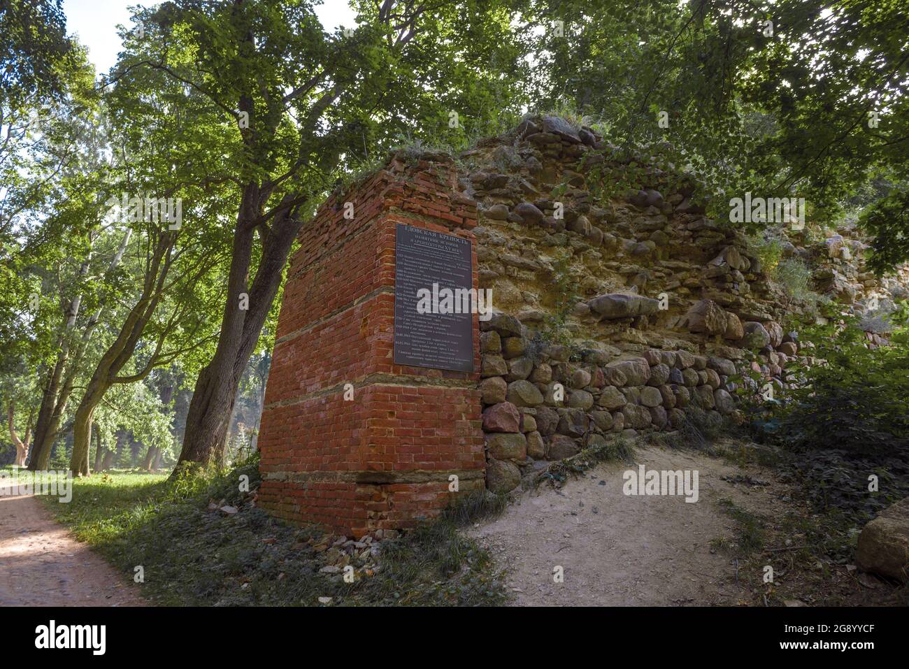 GDOV, RUSSLAND - 19. JULI 2020: Ruinen einer Verteidigungsmauer mit einer Gedenktafel an einem sonnigen Julitag. Festung Gdov Stockfoto