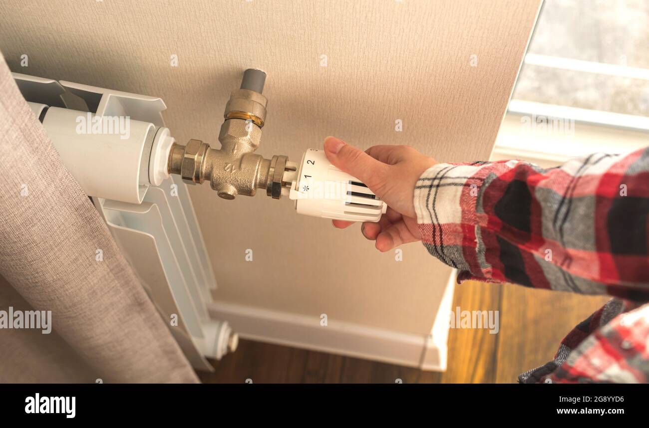 Frau Einstellung Heizung Heizkörper Thermostat drinnen Foto Stockfotografie  - Alamy