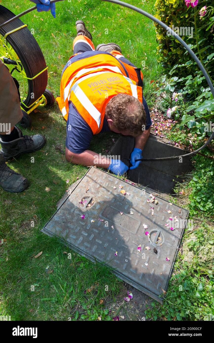 Fremdfirmen, die mit einer Kamera und einer Rolle Glasfaserkabel arbeiten, untersuchen ein verstopftes Kanalablasssystem auf Verstopfung und die Ursache des Problems. VEREINIGTES KÖNIGREICH. (127) Stockfoto