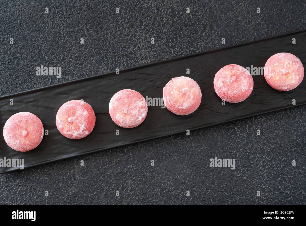 Mochi: Japanischer Reiskuchen auf dem schwarzen Servierteller Stockfoto