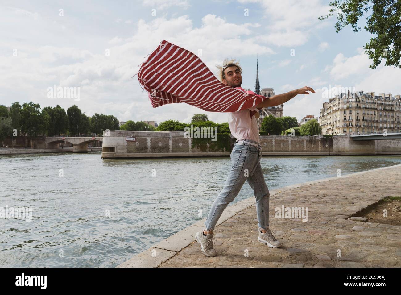 Mann winkt Decke am Fluss Stockfoto