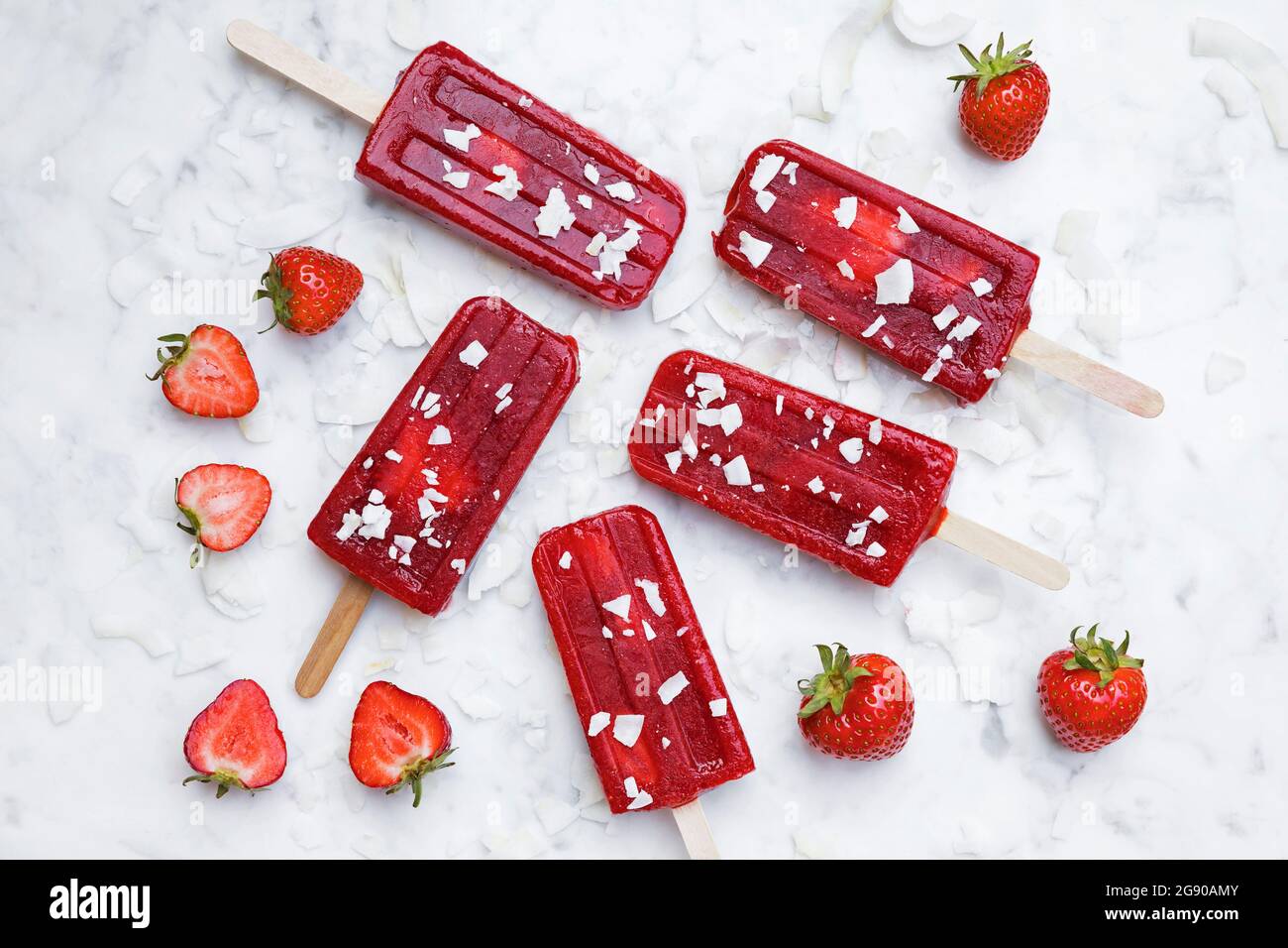 Hausgemachte Erdbeerpopsicles liegen auf Marmoroberfläche Stockfoto