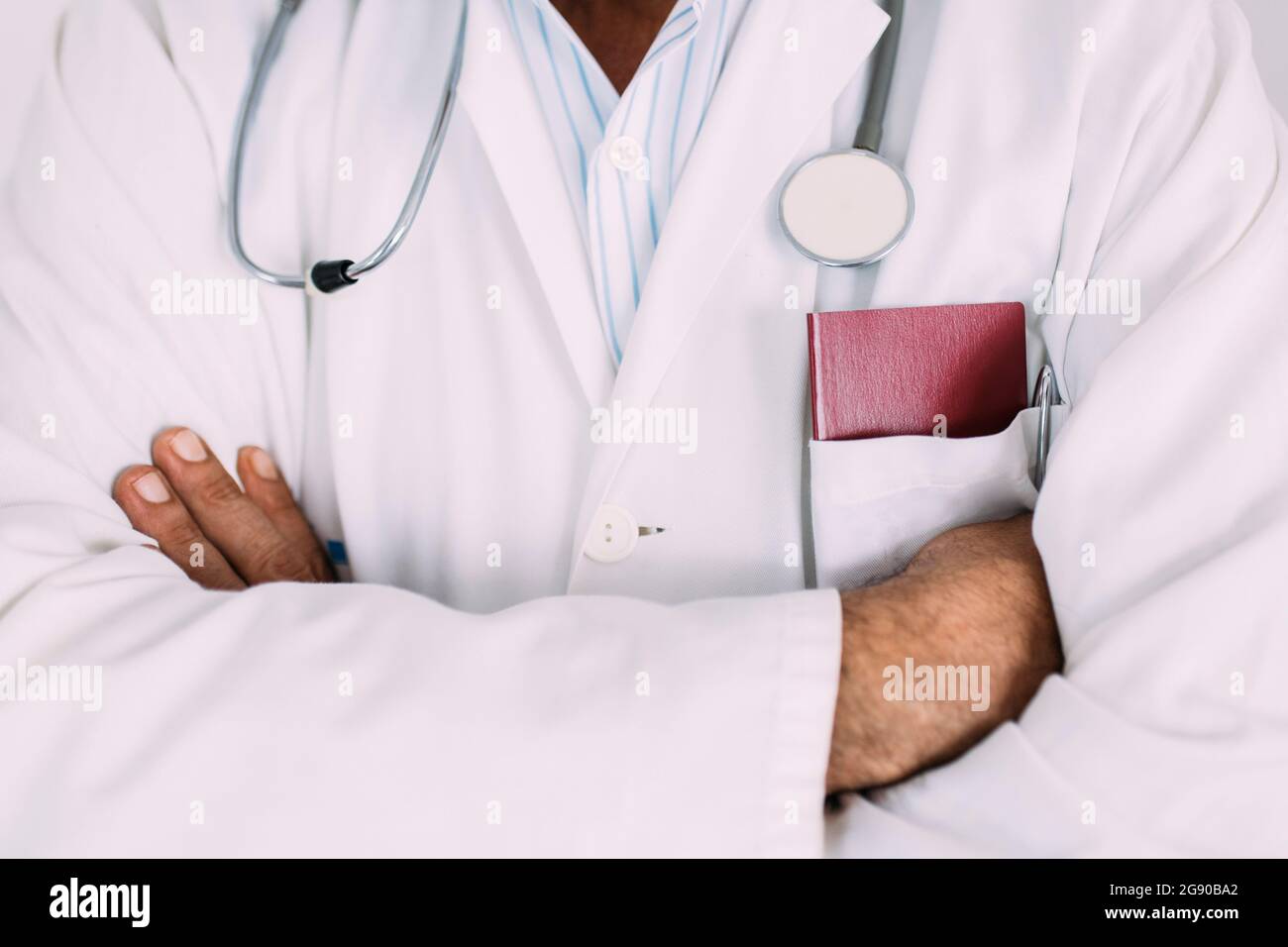 Leitender Arzt mit gekreuzten Armen im Krankenhaus Stockfoto