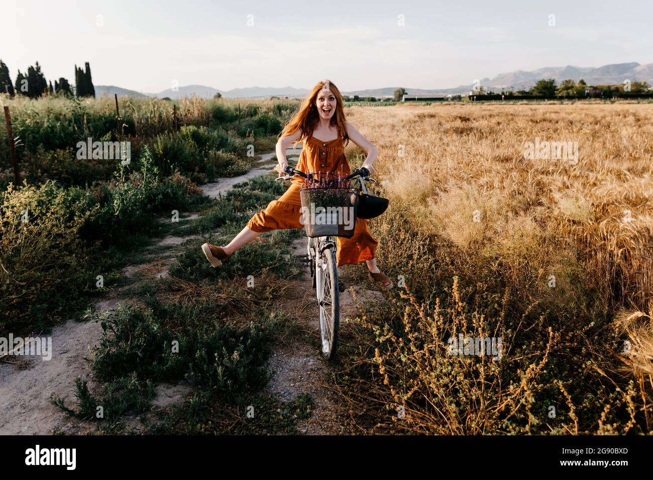 Sorglose Frau Fahrrad fahren in landwirtschaftlichen Bereich Stockfoto