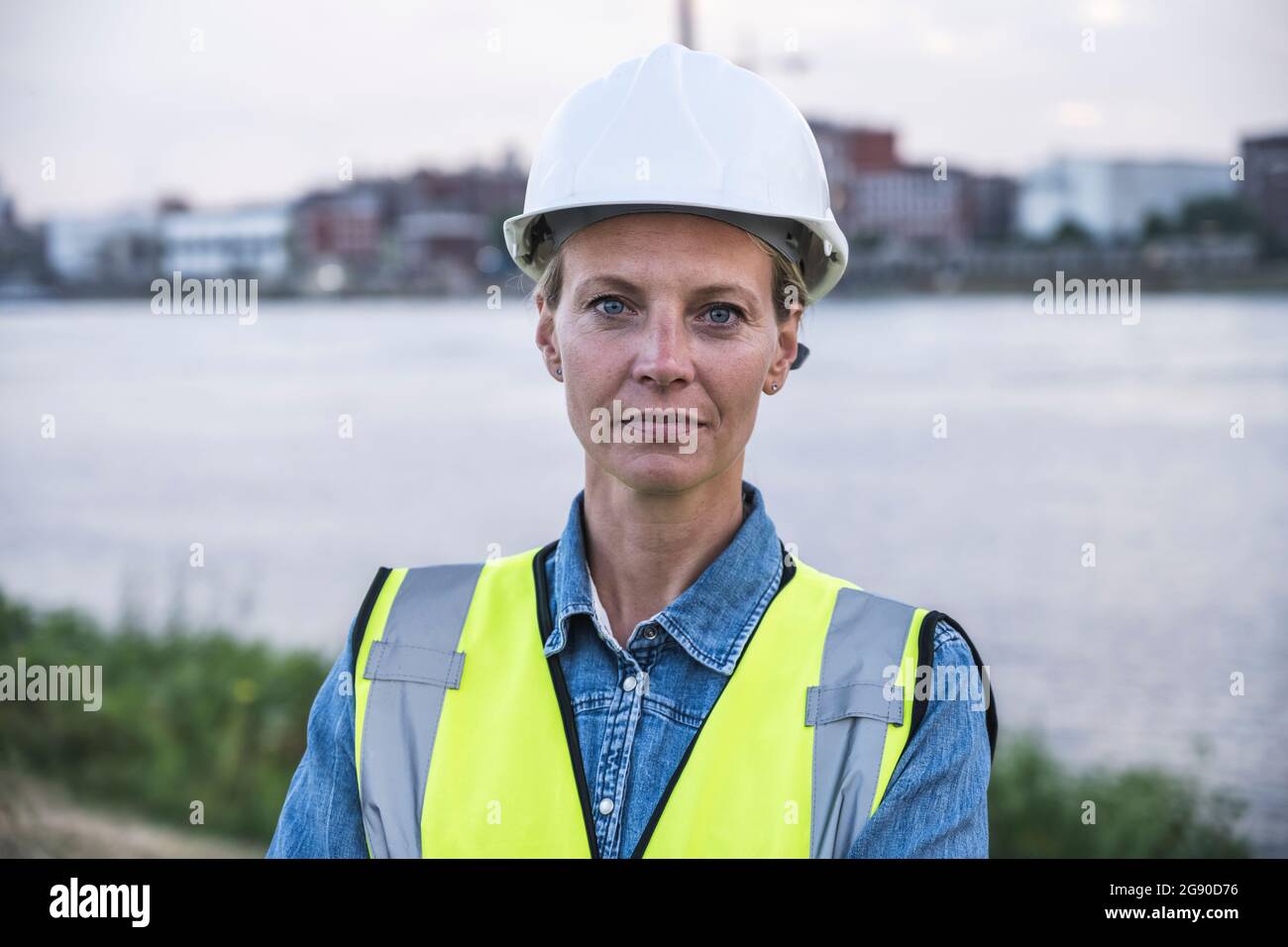 Selbstbewusste professionelle Frau mit Schutzkleidung bei Sonnenuntergang Stockfoto