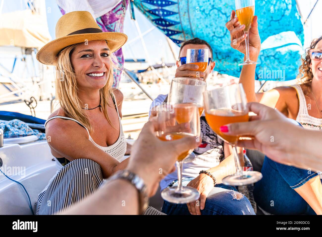 Glückliche männliche und weibliche Freunde, die auf der Yacht anstoßen Stockfoto