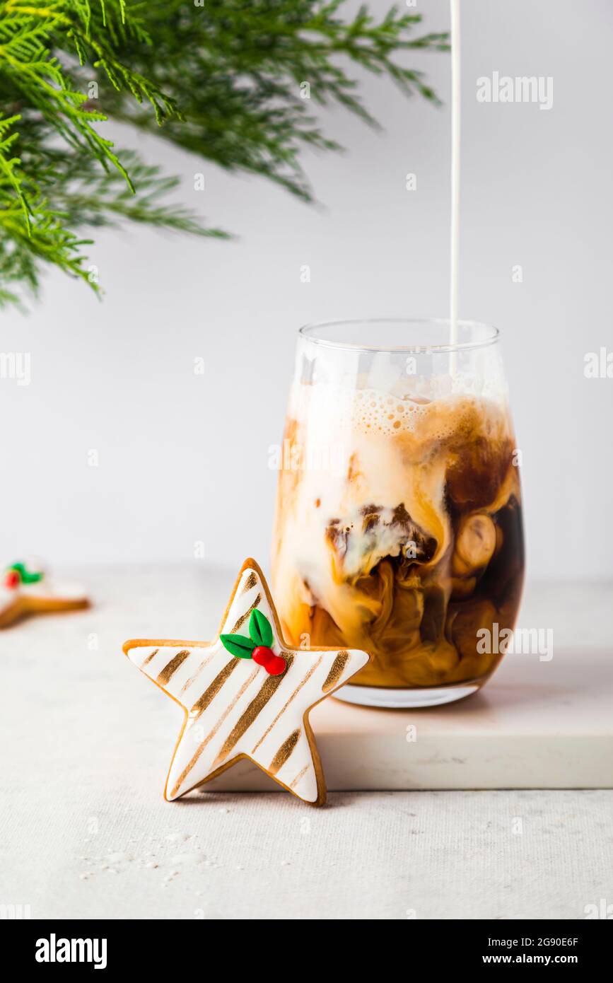 Sternförmige Weihnachtskekse und ein Glas Eiskaffee Stockfoto