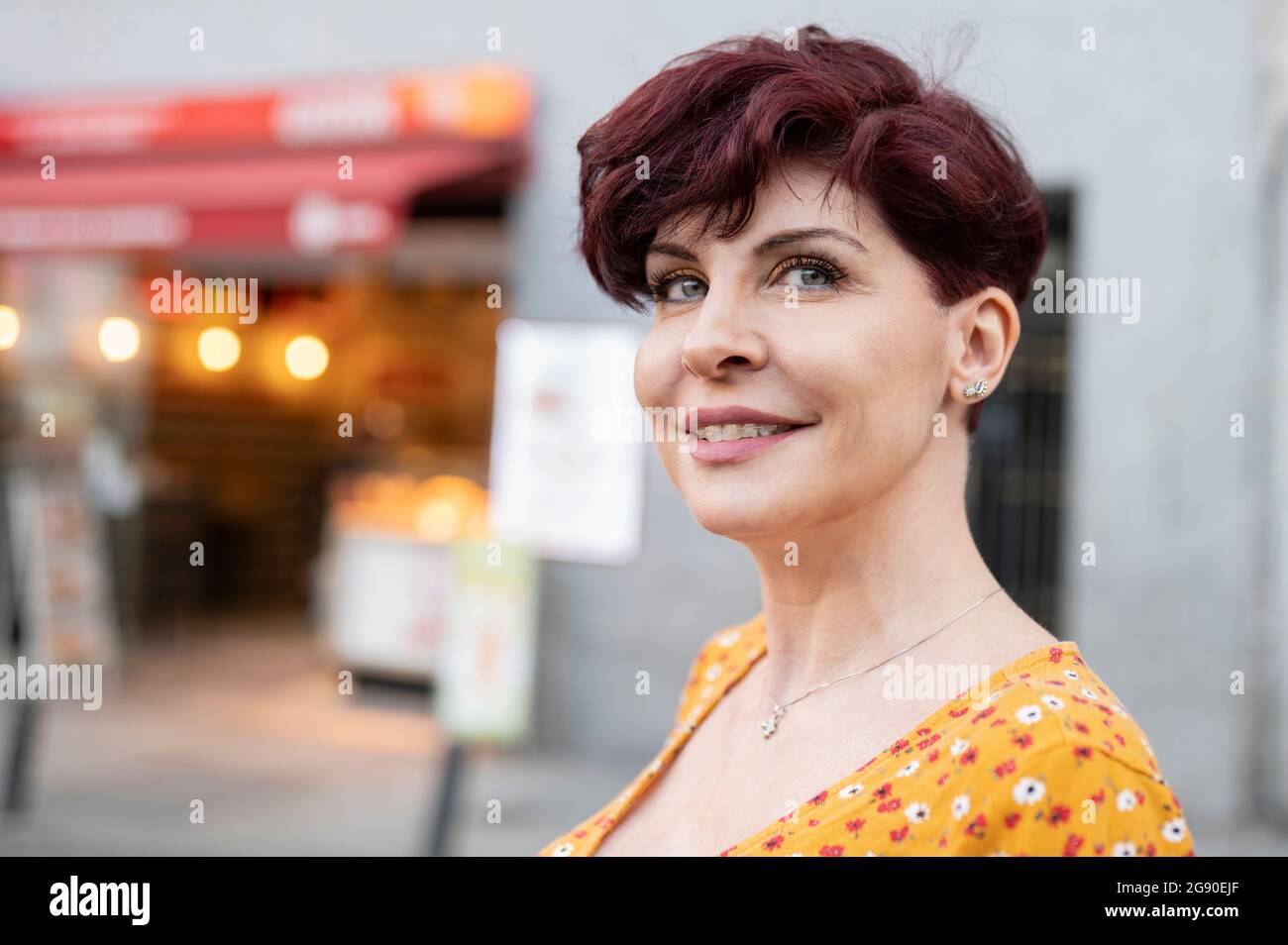 Lächelnde reife Frau mit kurzen Haaren Stockfoto