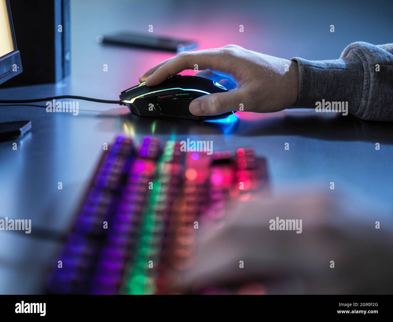 Junge mit beleuchteten Gaming-Maus, während Videospiel spielen Stockfoto