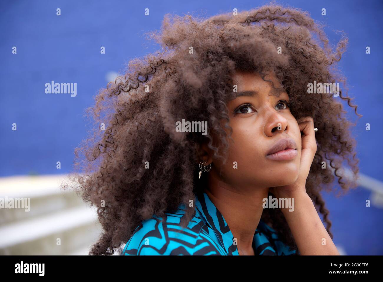 Nachdenkliche Afro-Frau mit der Hand am Kinn Stockfoto