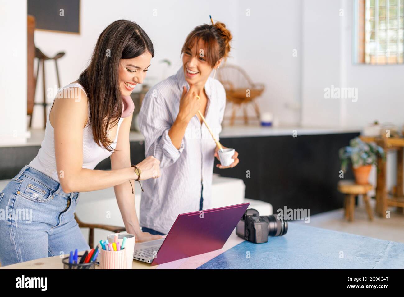 Glückliche weibliche kreative Profis diskutieren im Studio Stockfoto